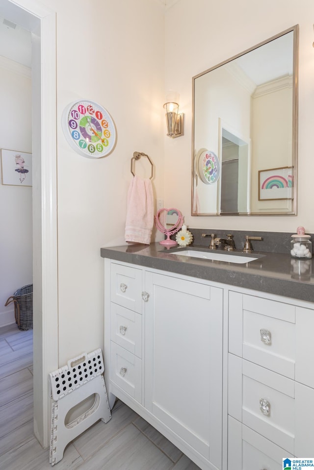 bathroom featuring vanity, hardwood / wood-style floors, and ornamental molding