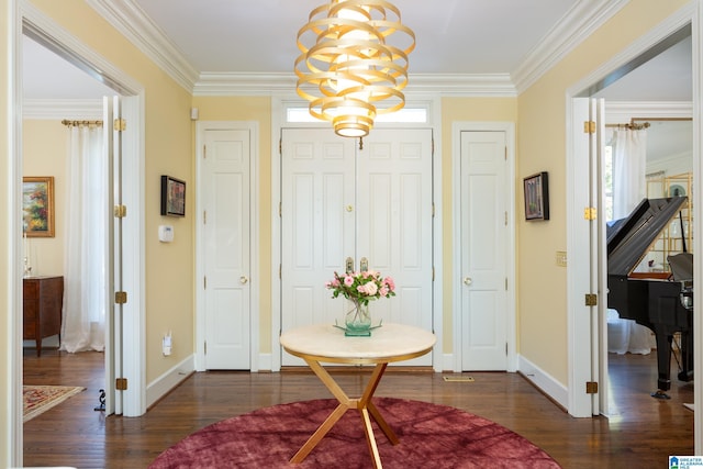 foyer with ornamental molding, a notable chandelier, baseboards, and dark wood finished floors
