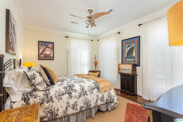 bedroom featuring ornamental molding, wood-type flooring, and ceiling fan