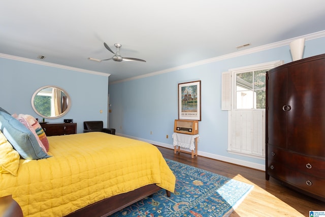 bedroom featuring wood finished floors, baseboards, visible vents, a ceiling fan, and crown molding