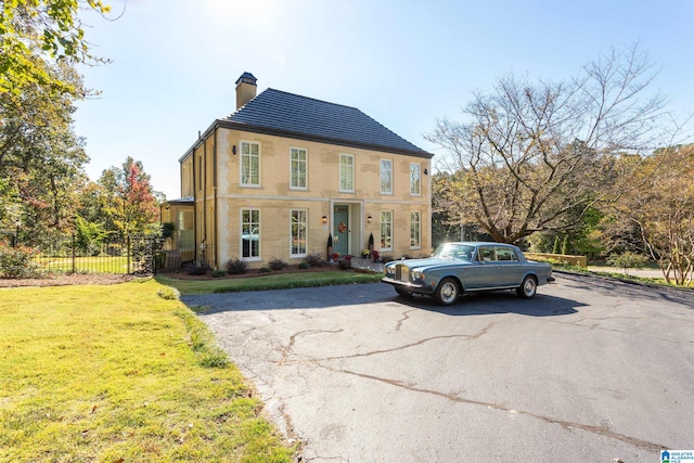 colonial-style house with a front lawn and central AC unit