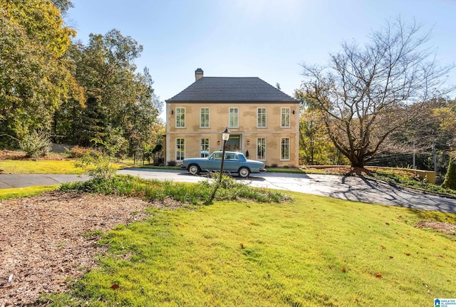 back of property with a garage and a lawn