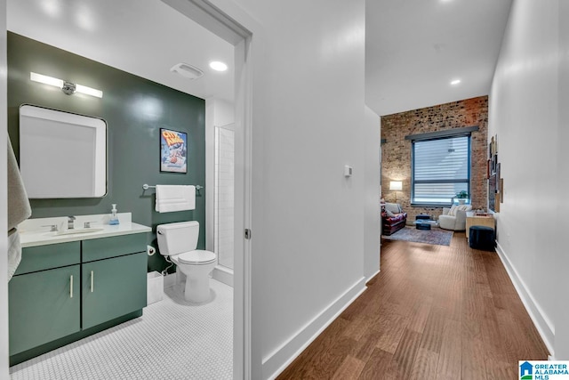 bathroom with toilet, hardwood / wood-style flooring, and vanity