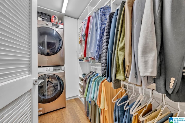 laundry room featuring stacked washer / drying machine and hardwood / wood-style flooring