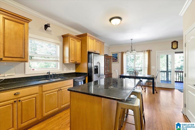 kitchen with a center island, light wood-type flooring, plenty of natural light, and stainless steel fridge with ice dispenser