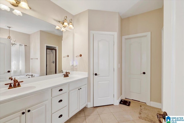 bathroom featuring vanity, a tub to relax in, an inviting chandelier, and tile patterned flooring