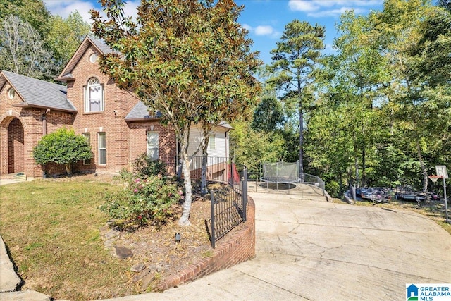 view of front of property featuring a front yard and a trampoline