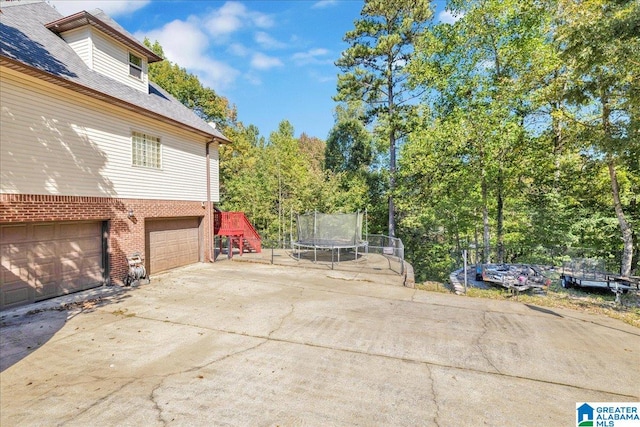 view of patio featuring a garage and a trampoline