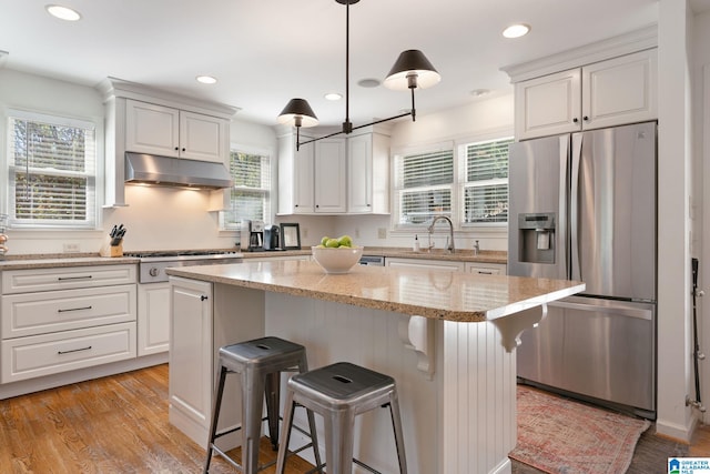 kitchen featuring white cabinets, stainless steel appliances, and a wealth of natural light