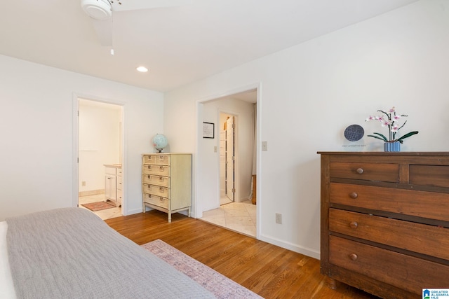 bedroom with ensuite bath, light wood-type flooring, and ceiling fan