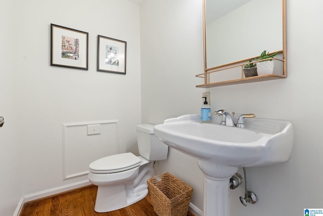 bathroom featuring toilet and wood-type flooring