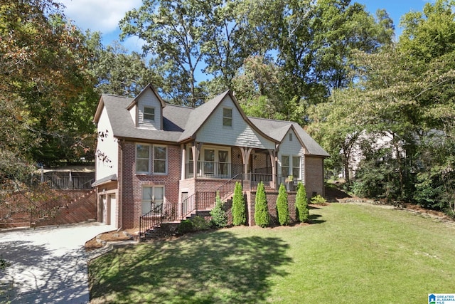 view of front of property with a garage, a front lawn, and a porch