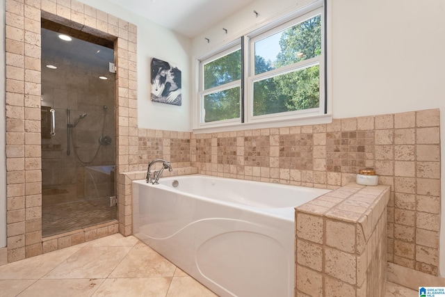 bathroom featuring tile walls, independent shower and bath, and tile patterned flooring