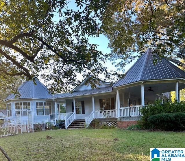 rear view of house with covered porch and a lawn