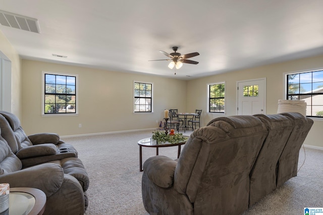 living room with light carpet, ceiling fan, and a healthy amount of sunlight