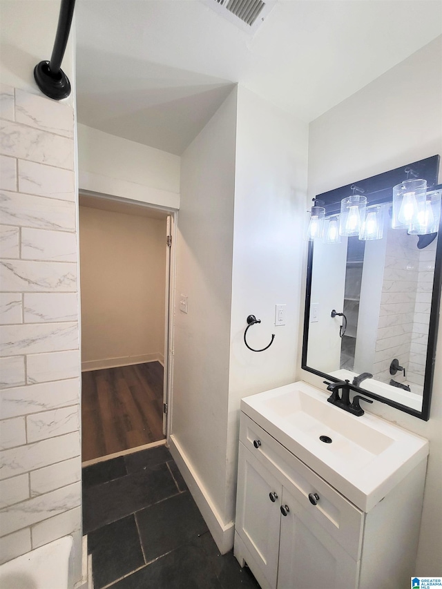 bathroom featuring vanity, hardwood / wood-style flooring, and a tub