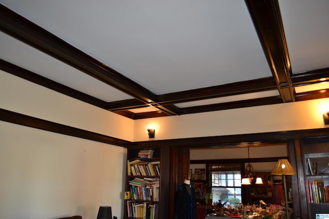 room details featuring beam ceiling, coffered ceiling, and an inviting chandelier