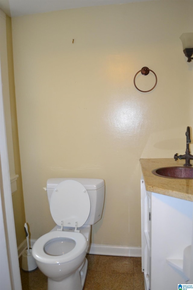 bathroom with toilet, vanity, and tile patterned floors