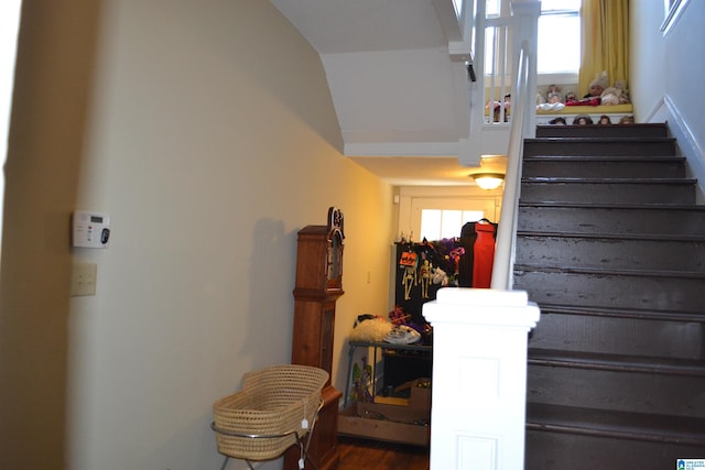 stairs with wood-type flooring and lofted ceiling