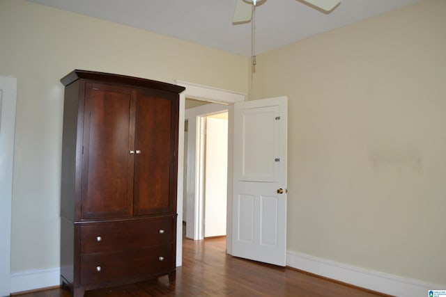 unfurnished bedroom featuring ceiling fan and dark wood-type flooring