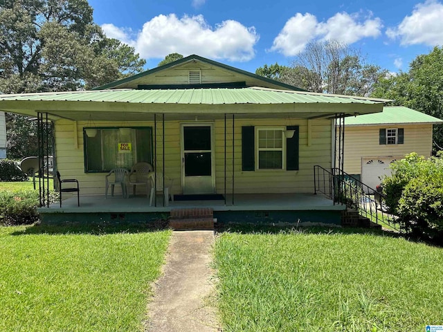 bungalow-style house with a front yard, a porch, and a garage