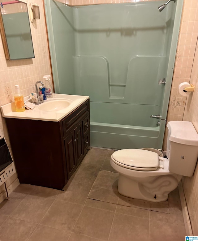 full bathroom with toilet, shower / bath combination, tile patterned floors, tile walls, and vanity