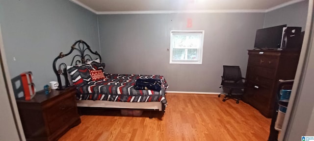 bedroom with light hardwood / wood-style floors and ornamental molding