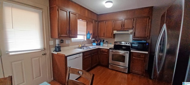 kitchen with sink, appliances with stainless steel finishes, and wood-type flooring