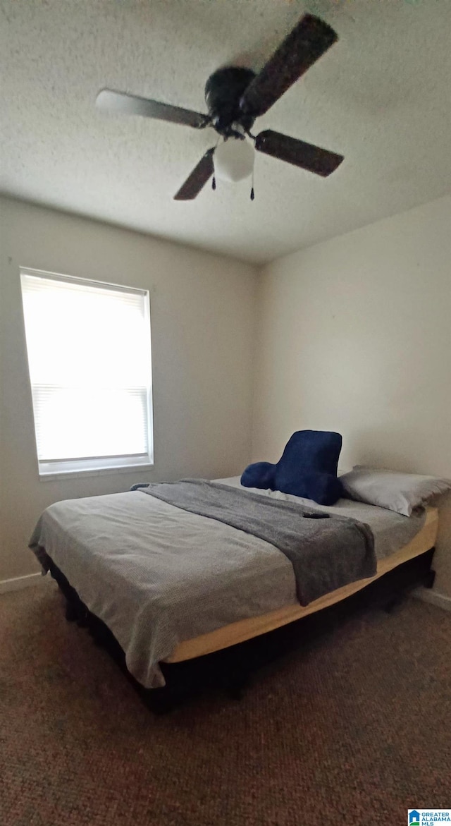 carpeted bedroom with a textured ceiling and ceiling fan