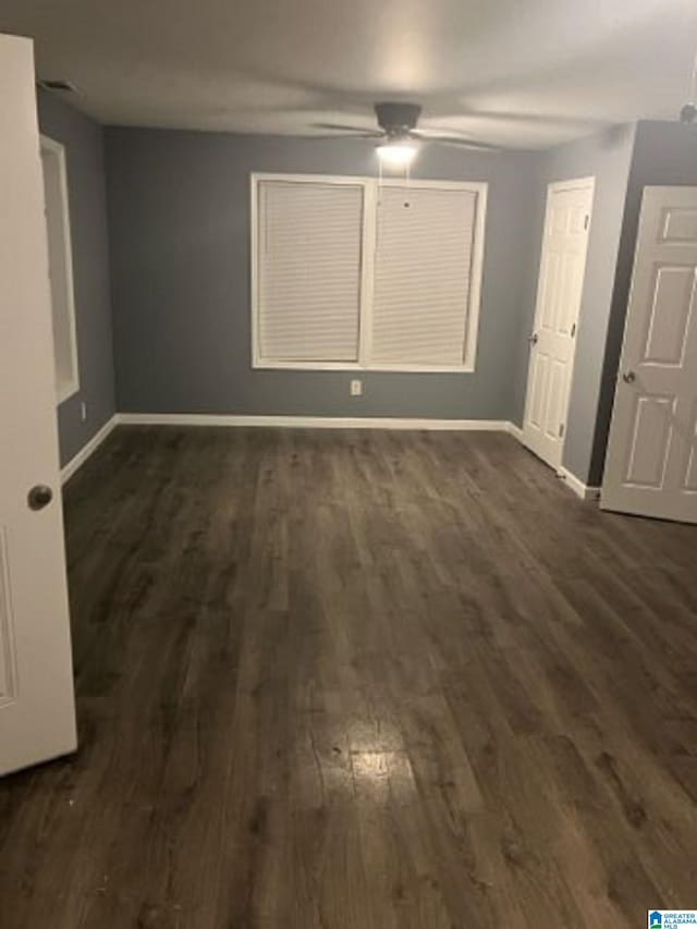 unfurnished bedroom featuring a ceiling fan, dark wood finished floors, and baseboards