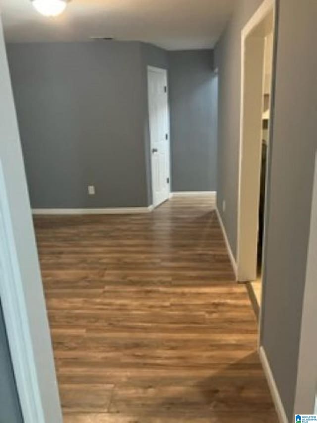 corridor with wood finished floors and baseboards