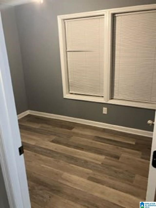 empty room featuring baseboards and wood finished floors