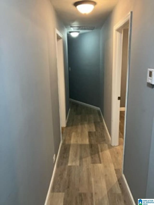 corridor featuring wood finished floors and baseboards