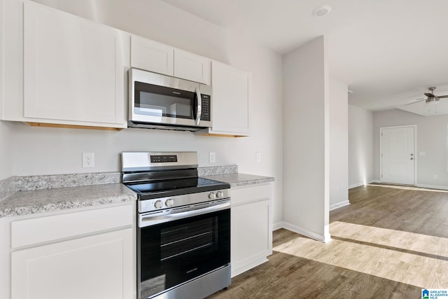 kitchen featuring ceiling fan, white cabinetry, stainless steel appliances, light stone countertops, and light hardwood / wood-style floors