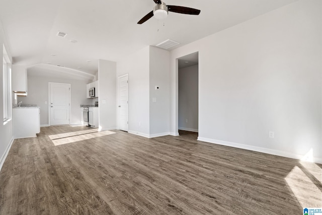 unfurnished living room featuring wood-type flooring, lofted ceiling, and ceiling fan