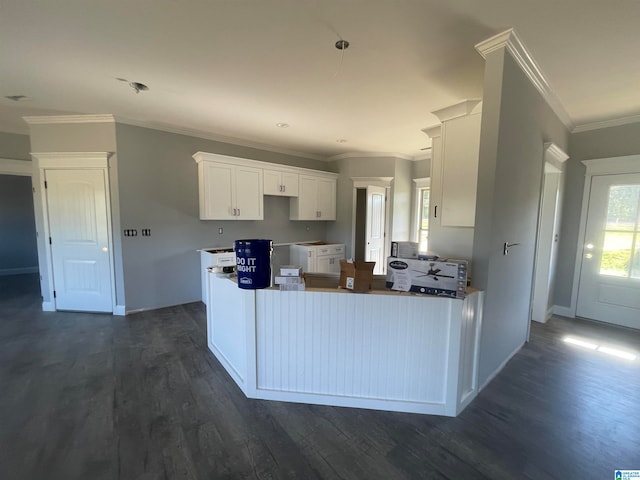 kitchen with dark wood-type flooring, white cabinetry, crown molding, and a wealth of natural light