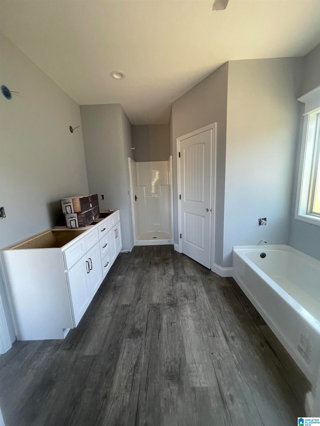 bathroom featuring hardwood / wood-style floors, vanity, and plus walk in shower