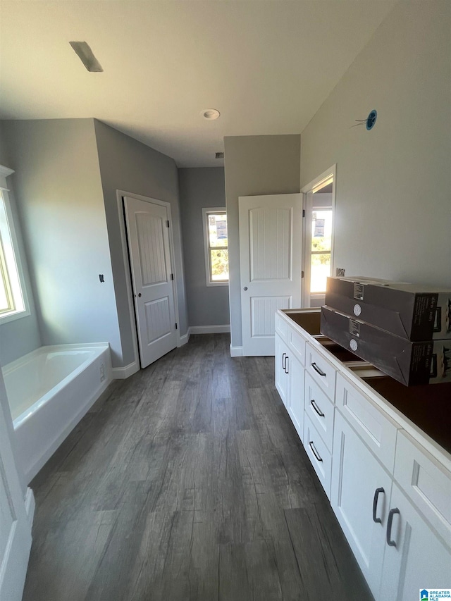 bathroom with vanity, wood-type flooring, and a bath