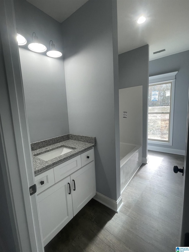 bathroom with vanity and a washtub