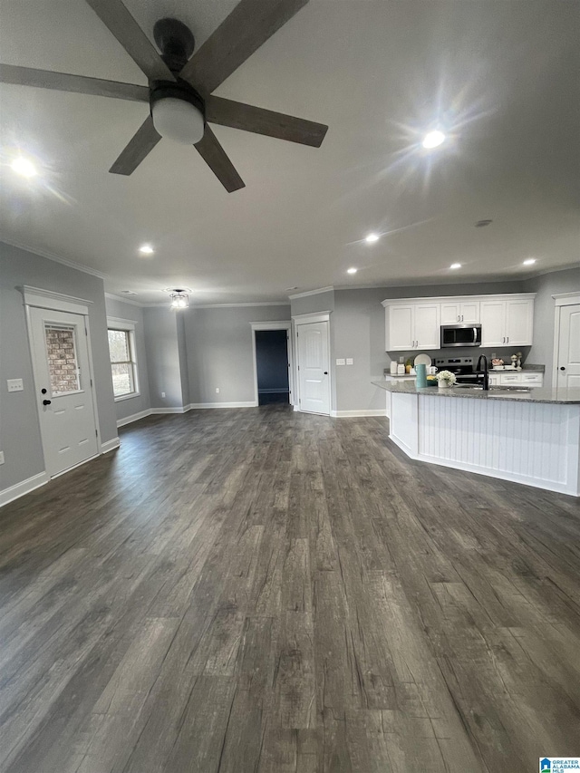 unfurnished living room with ceiling fan, dark wood-type flooring, sink, and ornamental molding