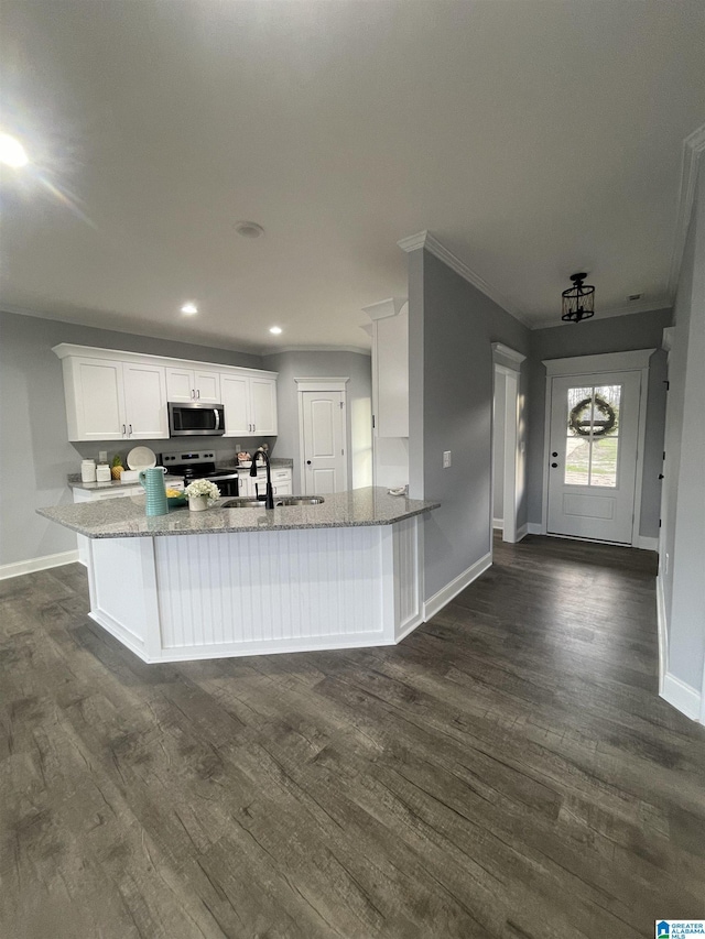 kitchen with kitchen peninsula, sink, dark wood-type flooring, stainless steel appliances, and white cabinets