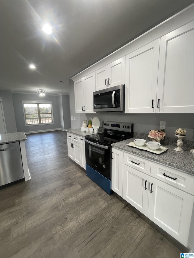 kitchen featuring white cabinets, appliances with stainless steel finishes, light stone counters, and dark hardwood / wood-style floors