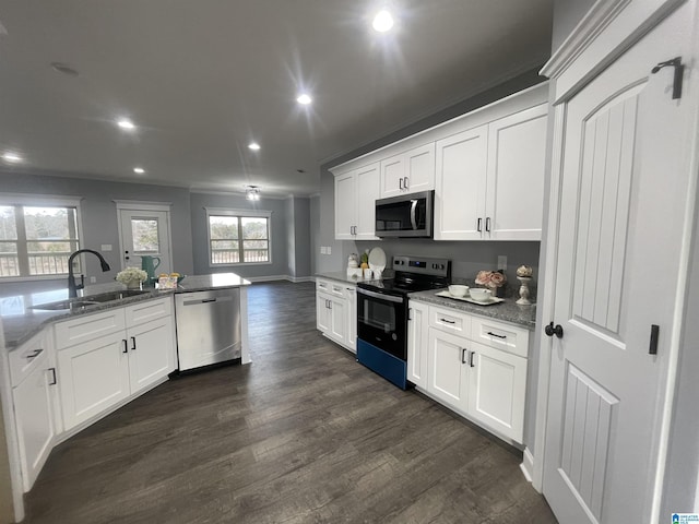 kitchen with dark hardwood / wood-style floors, sink, appliances with stainless steel finishes, white cabinets, and stone countertops