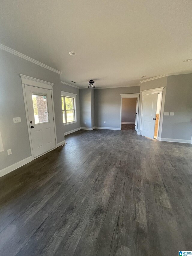 unfurnished living room with dark hardwood / wood-style flooring and ornamental molding