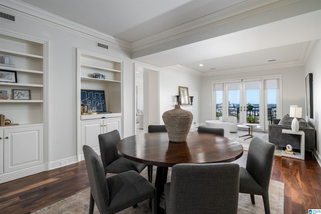 dining area featuring dark wood-type flooring, crown molding, french doors, and built in features