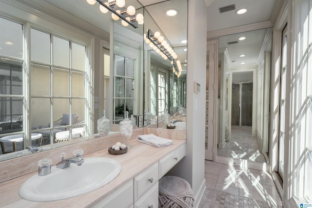 bathroom featuring vanity, crown molding, and tile patterned flooring