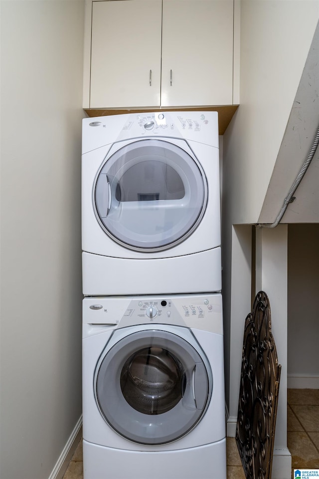 washroom featuring stacked washing maching and dryer and tile patterned floors