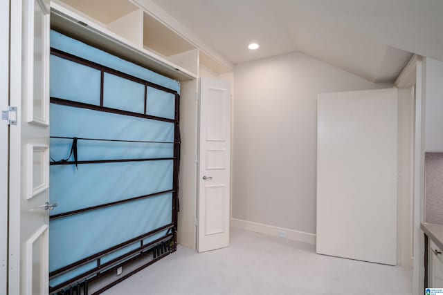 interior space with light carpet and lofted ceiling