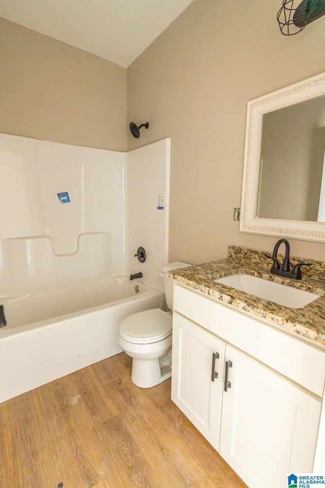 full bath with toilet, tub / shower combination, vanity, and wood finished floors