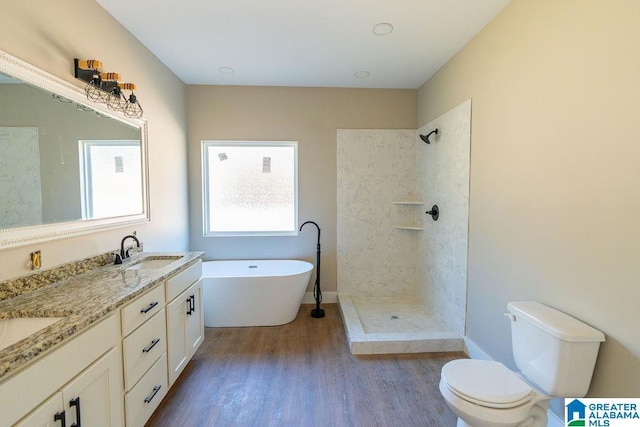 bathroom with toilet, tiled shower, wood finished floors, a soaking tub, and a sink